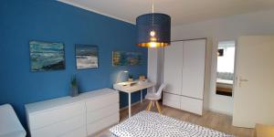 a room with a desk and a blue wall at F3 - "Gemütlich mit Kunst" in Dresden