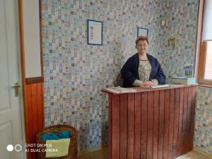 a woman standing at a wooden counter in a room at Hostel Vokzal in Mukacheve