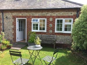 a brick house with a table and chairs in the yard at The Hen House in Chichester