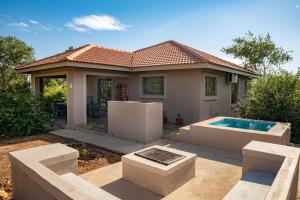 a house with a swimming pool in front of it at Impala Lily in Marloth Park