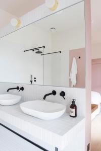 a bathroom with two sinks and a mirror at Maison Aribert in Saint-Martin-dʼUriage