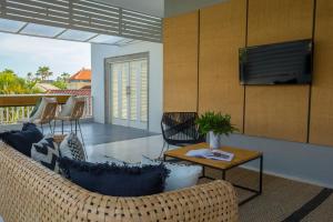 a living room with a couch and a television at Origin Seminyak in Seminyak