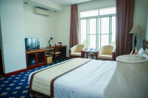 ein Hotelzimmer mit einem Bett und einem TV in der Unterkunft NGAN HA HOTEL in Ðại Tiêt