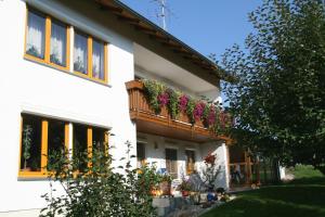 a white house with flowers on the balcony at Ferienwohnung Lex in Bad Griesbach