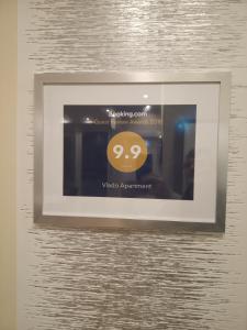 a picture frame hanging on a wall with a smileys achievement at Vlado Apartment in Belgrade