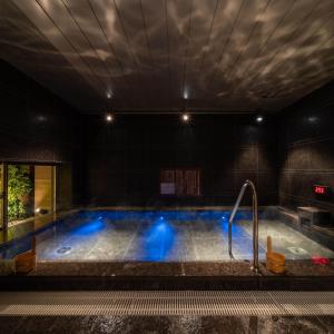 a large swimming pool with blue lights in a building at Super Hotel Premier Ginza in Tokyo
