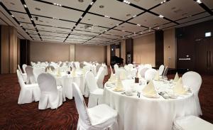 een kamer vol tafels en stoelen met witte tafelkleden bij Parksunshine Jeju in Seogwipo
