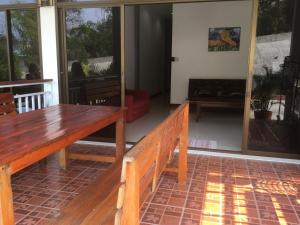 a living room with a wooden bench and windows at Anong's 2 bedroom family home for up to 6 guests in Ko Samed