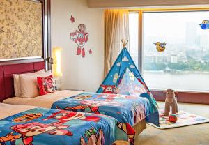 a bedroom with two beds and a toy tent at Shangri-la Guangzhou -Traffic free, 3 minutes walk to Canton Fair & Overseas Buyers Registration Service in Guangzhou
