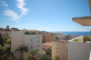 uma vista para uma cidade com edifícios e palmeiras em Appartement Les Fauvettes em Cannes
