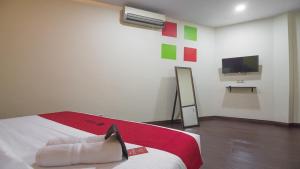 雅加達的住宿－RedDoorz near ITC Mangga Dua，一间设有床铺和墙上电视的房间