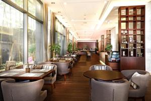 a restaurant with tables and chairs and windows at Parksunshine Jeju in Seogwipo