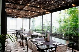 - un restaurant avec des tables, des chaises et de grandes fenêtres dans l'établissement Petit Palace Santa Bárbara, à Madrid