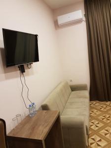 a living room with a couch and a flat screen tv at Hotel Classic in Tbilisi City
