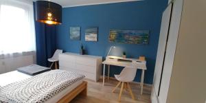 a bedroom with a bed and a desk with a computer at F3 - "Gemütlich mit Kunst" in Dresden