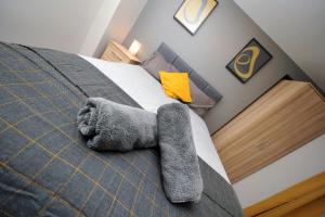 a bedroom with a bed with a gray blanket at Stone's Throw City Centre - TV in every Bedroom! in Swansea