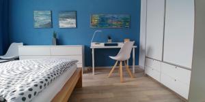 a bedroom with a bed and a desk with a chair at F3 - "Gemütlich mit Kunst" in Dresden