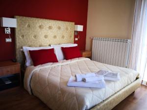 1 dormitorio con 1 cama grande y toallas. en Sant'Oronzo B&B, en Lecce