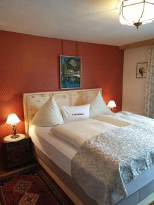 uma cama grande num quarto com paredes vermelhas em S'Hoamatl em Höfen