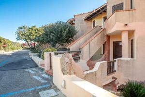 un bâtiment avec une clôture à côté d'une rue dans l'établissement Residence La Marmorata - IUN F0146 -, à Santa Teresa Gallura