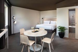 une chambre d'hôtel avec un lit, une table et des chaises dans l'établissement INNSiDE by Meliá Paris Charles de Gaulle Airport, à Roissy-en-France