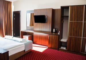 a hotel room with a bed and a flat screen tv at Legend Business Hotel Batumi in Batumi