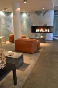 - un salon avec un canapé et une cheminée dans l'établissement Fletcher Hotel - Restaurant Elzenduin, à Ter Heijde