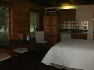 a bedroom with a bed and a table and chairs at Cool Springs Inn in Michigan City
