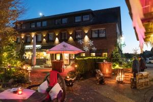 a person sitting at a table in front of a building at Landhotel-Restaurant Beckmann in Heiden