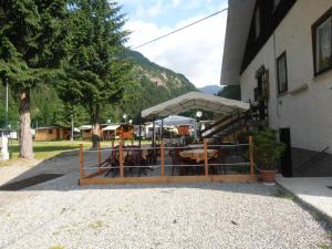 a building with a fence with a tent in front of it at Campodolcino Camping in Campodolcino