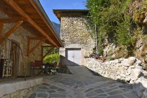 ein Steingebäude mit einer weißen Tür und einer Steinmauer in der Unterkunft Gite de charme la Chabotte - Royans / Vercors in Châtelus