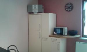 a white cabinet with a microwave on top of it at Ferienwohnung ROSA in Hahausen