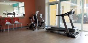 a gym with treadmills and exercise bikes in a room at Domitys Les Gréements d'Or in Douarnenez