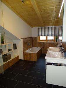 ein großes Bad mit einer Badewanne und einem Waschbecken in der Unterkunft Ferienwohnung am Eck in Bad Hindelang