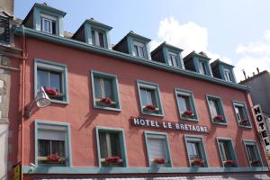 un edificio rojo con flores en las ventanas en Le Bretagne - Hôtel Spa & Sauna en Douarnenez