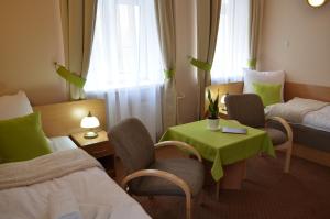 een hotelkamer met 2 bedden en een tafel en stoelen bij Willa Ostoja in Inowrocław