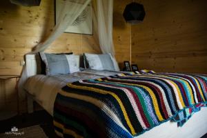 a bedroom with a bed with a colorful blanket on it at Zielna Farma in Blanki