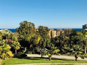 park z palmami i oceanem w tle w obiekcie Edifício Hercules w mieście Benalmádena