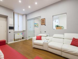 ein Wohnzimmer mit einem weißen Sofa und roten Kissen in der Unterkunft NATIONAL Luxury apartment in Rom