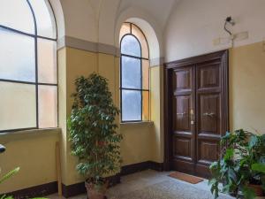 einen Flur mit Holztür und Pflanze in der Unterkunft NATIONAL Luxury apartment in Rom