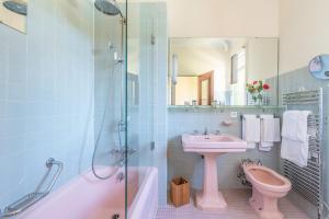 a bathroom with a toilet, sink and tub at Le Grand Hôtel in Moltig les Bains