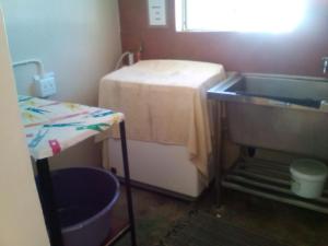 a small bathroom with a sink and a table at Kai-Oms Backpackers Lodge in Outjo