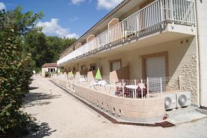 a balcony of a building with tables and chairs at Appart'Hôtel Les Rochers in Auriol