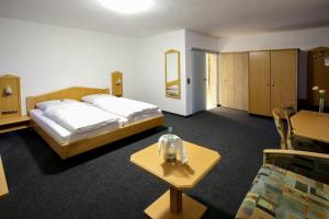 Cette chambre comprend 2 lits et une table basse. dans l'établissement Spirklhof, à Bodenkirchen