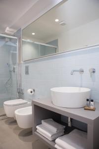 a bathroom with a sink and a toilet and a mirror at Cocor Suites & Design in Naples