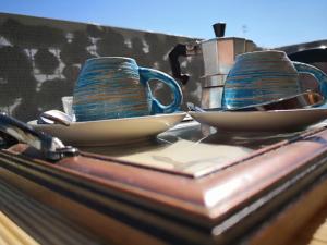 Dois copos azuis e pires sentados num balcão. em Sant'Oronzo B&B em Lecce
