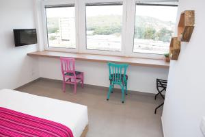 two chairs sitting in a room with two windows at Cocor Suites & Design in Naples