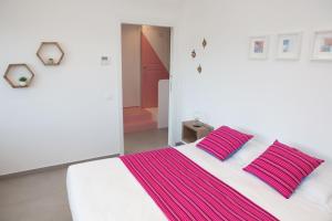 a bedroom with a white bed with pink and purple stripes at Cocor Suites & Design in Naples