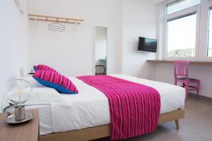 a bedroom with a bed with a pink blanket on it at Cocor Suites & Design in Naples