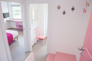 a room with pink chairs and a bed and a table at Cocor Suites & Design in Naples